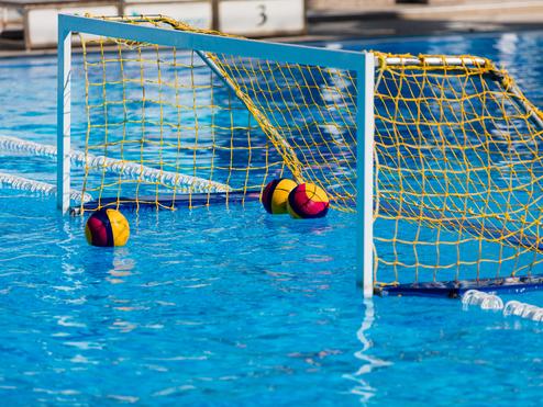 Wassertor mit bunten Wasserbällen im Becken, umgeben von blauer Wasseroberfläche.